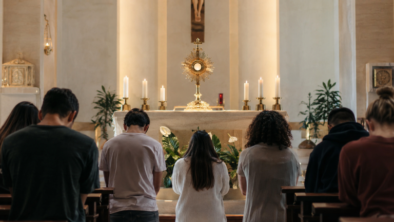Jóvenes católicos reunidos en adoración eucarística durante un momento de oración y silencio